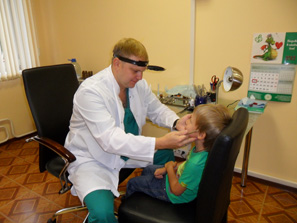 Детский ЛОР-врач Андрей Викторович Олейник осматривает маленького пациента