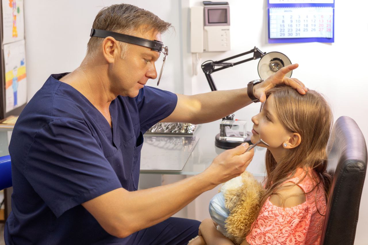 Детский ЛОР-врач Андрей Викторович Олейник осматривает маленького пациента